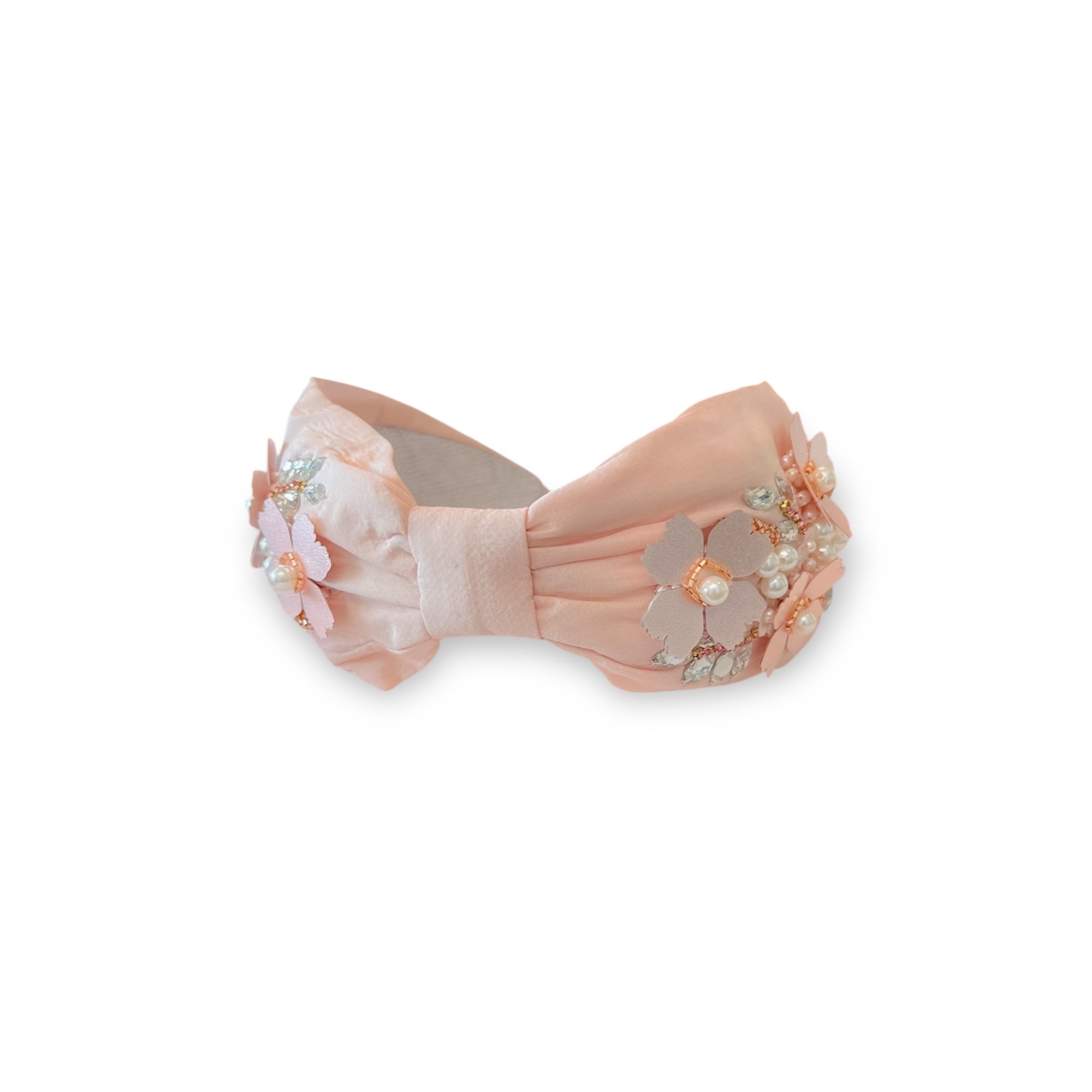 Decorative bow with floral and pearl embellishments on a white background