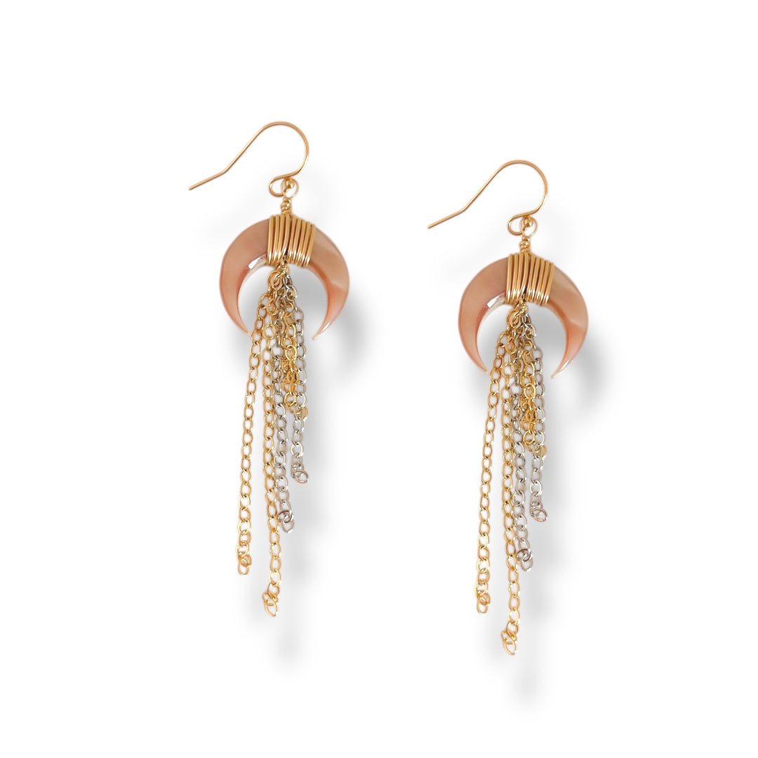 Pair of gold and copper earrings with dangling chains on a white background