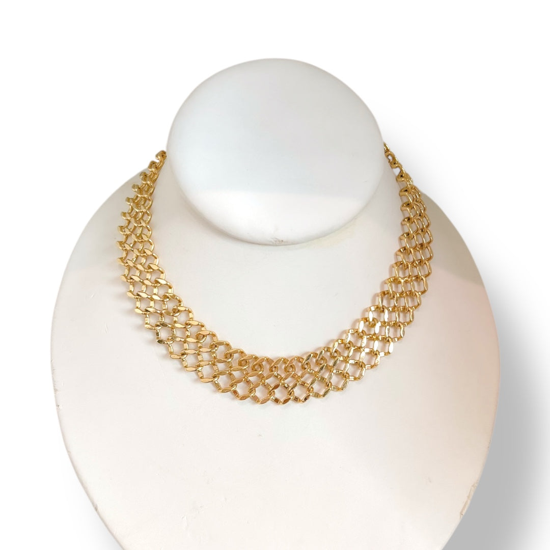 Gold necklace on a white mannequin bust with a plain background