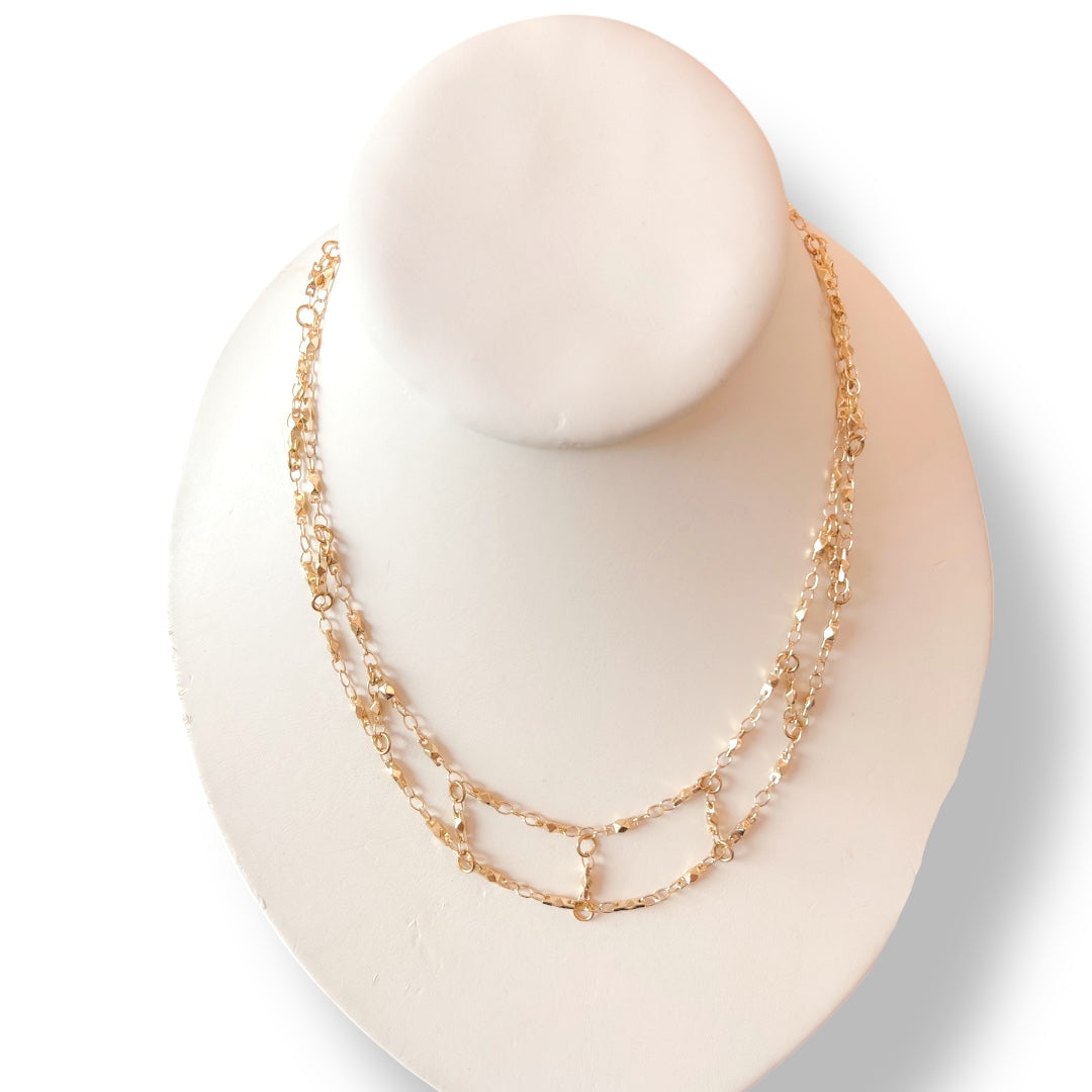 Gold necklace on a mannequin bust against a white background