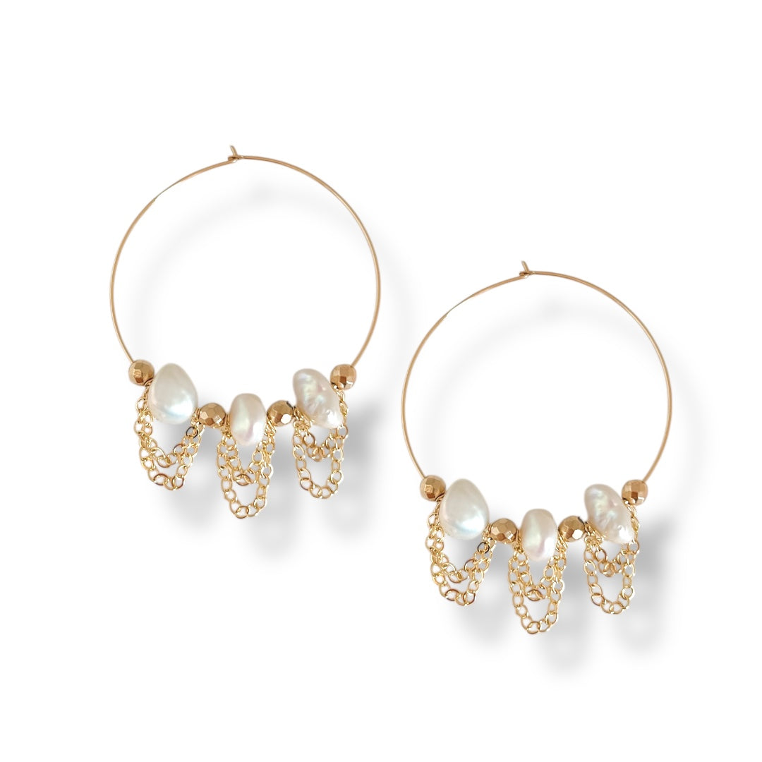 Gold hoop earrings with pearl accents on a white background