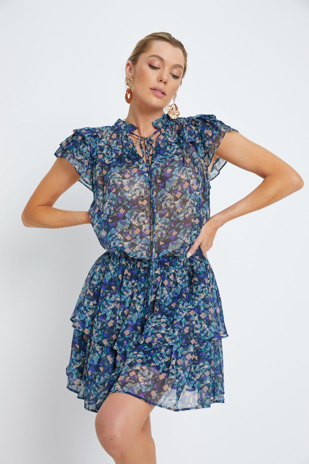 Woman wearing a blue floral dress against a white background