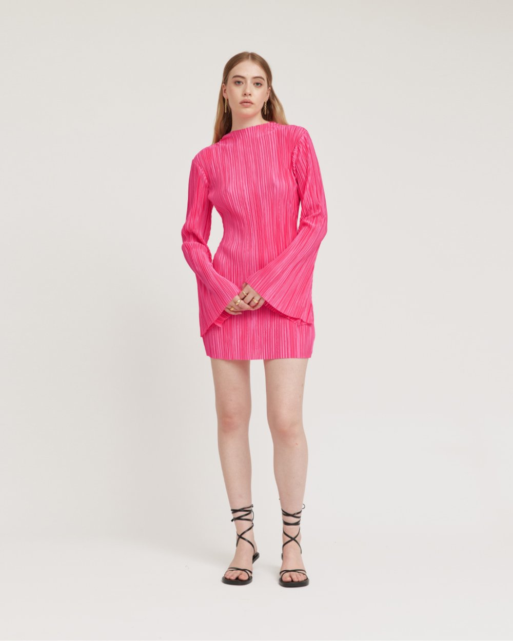 Woman wearing a bright pink dress on a white background