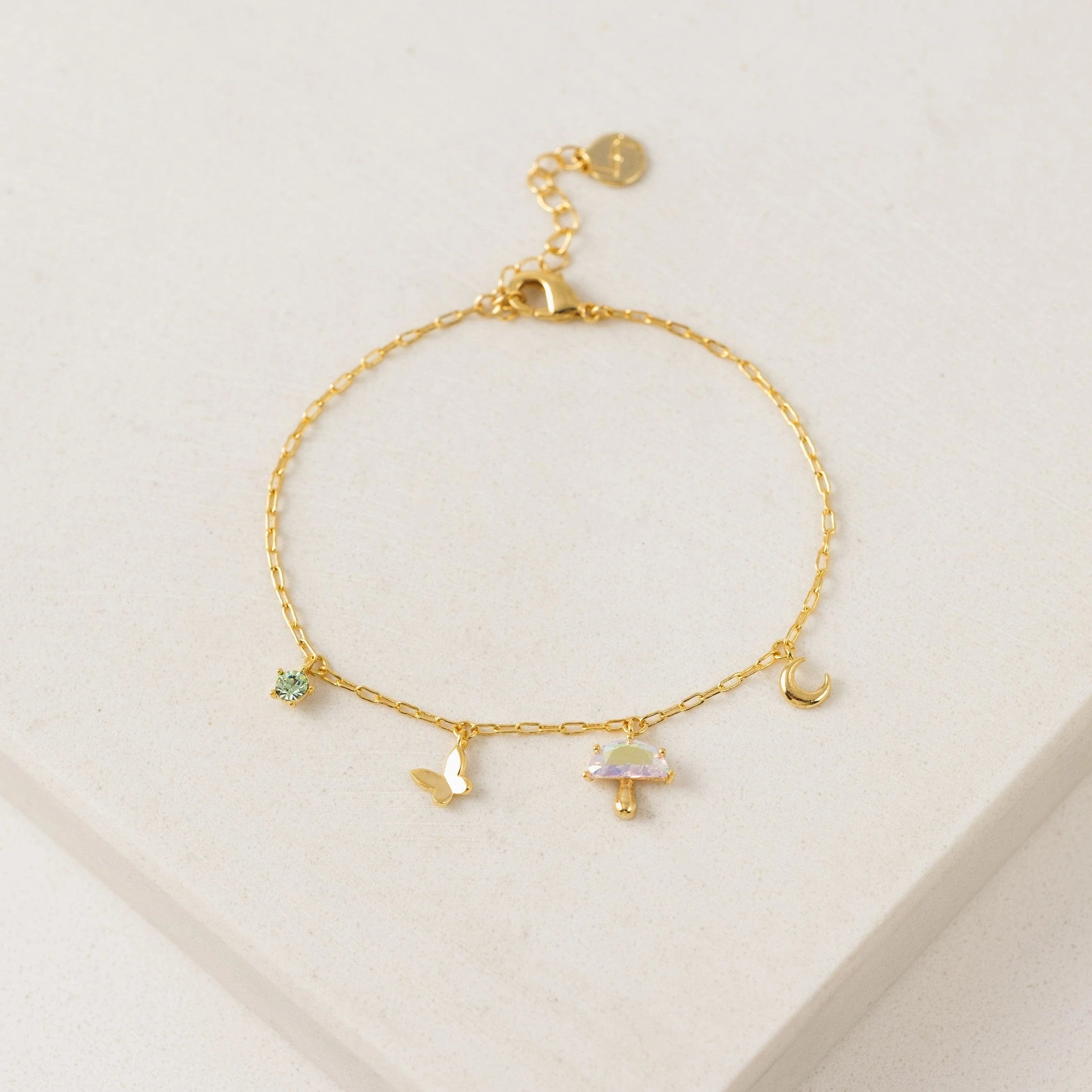 Gold bracelet with charms on a light gray background