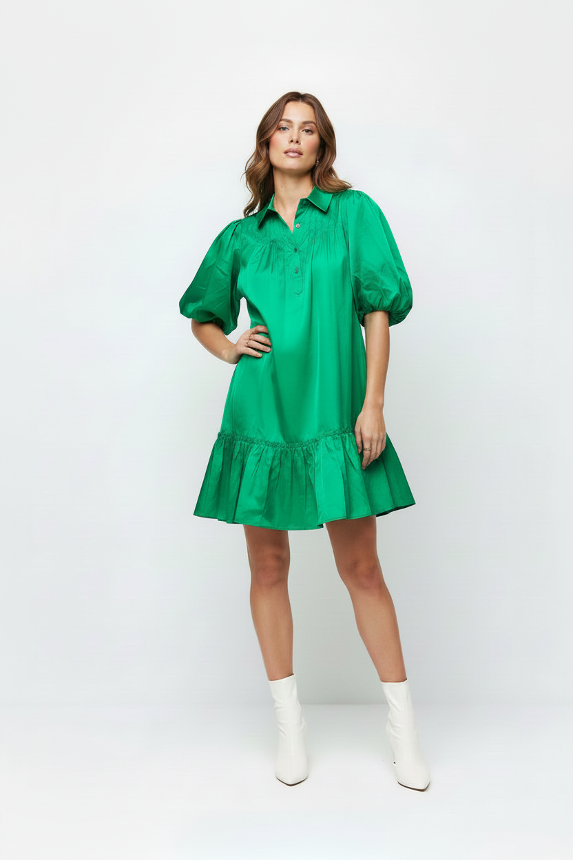 Woman wearing a green dress with white boots on a white background