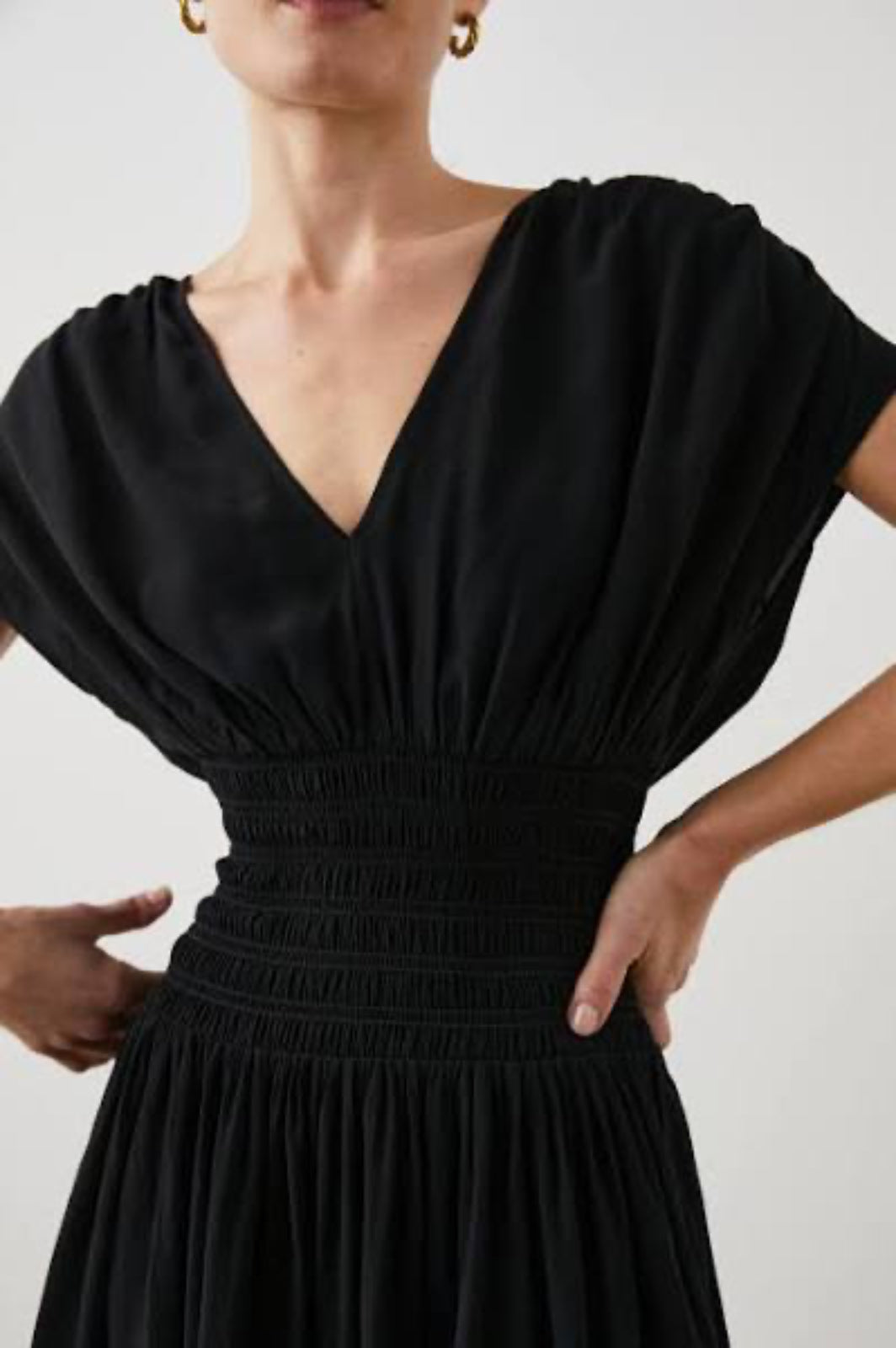 Black dress worn by a person on a plain background